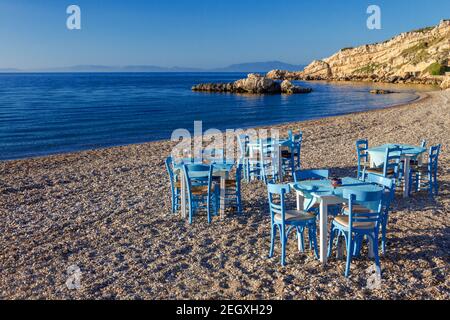 Chaises et table d'un restaurant grec sur la plage de Kokkari, sur l'île de Samos, en Grèce, en Europe. Banque D'Images