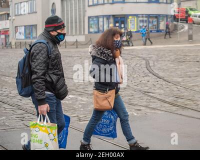 Brno, République tchèque. 02-17-2021. Homme et femme migrants avec masque pour protéger contre le virus corona marcher sur la station de tramway principale de Halvni Nadrazi dans le c Banque D'Images