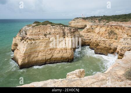 Vue côtière le long de la piste des sept Vallées suspendues avec phare de Farol de Alfanzina en arrière-plan, région de l'Algarve, Portugal Banque D'Images