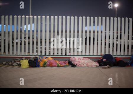 Tijuana, Mexique. 19 février 2021. Des dizaines de migrants d'origine centraméricaine et mexicaine dorment sur l'esplanade de l'Institut national des migrations, près du passage frontalier d'El Chaparral, en attendant que les autorités américaines les laissent entrer pour commencer leur processus d'asile humanitaire dans ce pays. Suite au changement d'orientation de la politique migratoire, le gouvernement américain autorise une fois de plus les demandeurs d'asile de l'autre côté de la frontière. Credit: dpa Picture Alliance/Alay Live News Banque D'Images