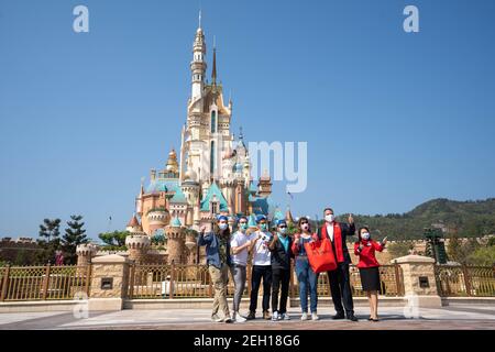 Michael Moriarty (R2), Le directeur général de Hong Kong Disneyland Resort pose pour la photo avec les visiteurs devant le château des rêves magiques lors de la réouverture de la station.le Hong Kong Disneyland Resort rouvre sa porte aux visières alors que le gouvernement de la ville a assoupli les restrictions de verrouillage comme le taux d'infection de la Le coronavirus Covid-19 a considérablement diminué ces derniers jours. Banque D'Images