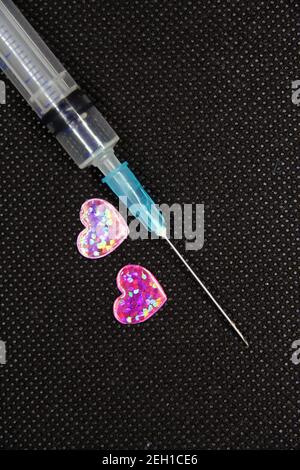 Seringue médicale et un coeur. Objet en forme de coeur et un traitement. Banque D'Images