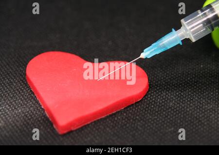 Seringue médicale et un coeur. Objet en forme de coeur et un traitement. Banque D'Images