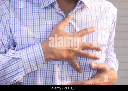 jeune homme souffrant de douleur dans le coeur et tenant la poitrine avec main Banque D'Images
