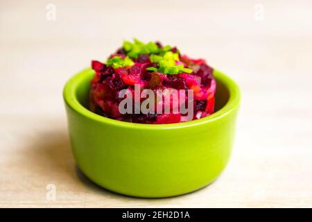 Salade de betteraves russes maison vinaigrette dans un bol vert sur blanc arrière-plan de la table Banque D'Images