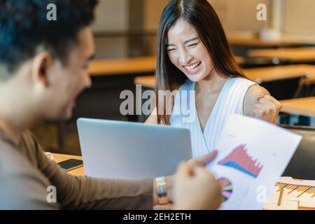 Vue arrière de Boss félicitant la femme d'affaires asiatique en action heureuse quand le projet réussi ou obtenir la promotion, récompensant l'objectif d'affaires en Mo Banque D'Images