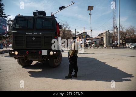 Un membre des gardes de l'opération spéciale est alerté à côté d'un véhicule blindé près du site de la fusillade à Srinagar.deux policiers ont été tués par des militants dans la région de Baghat sur la route de l'aéroport de haute sécurité à Srinagar, a déclaré la police. Plus tôt, au moins trois militants et un policier ont été tués dans deux combats distincts au Cachemire. Banque D'Images