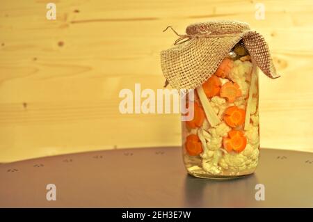 Concept de pot de cornichons de saison avec tomates vertes crues de couleur, carotte d'orange et chou-fleur blanc sur fond de bois naturel. Copier le texte. Banque D'Images