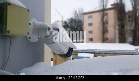 Grande caméra de surveillance blanche au-dessus d'une fenêtre sur la toile de fond d'un bâtiment public. Gros plan. Caméra CCTV installée sur la fenêtre extérieure du ho Banque D'Images