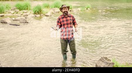 C'est votre endroit. Activités de loisir et de sport. Pêcheur barbu dans l'eau. Homme mature pêche à la mouche. Homme attrapant le poisson. Week-end d'été. Pêche à la mouche réussie. Pêcheur montre technique de pêche utilisez la tige. Banque D'Images