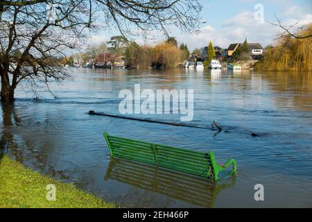 Un banc de parc partiellement submergé dans les eaux inondées de la Tamise dans le vieux Windsor près des prés de Runnymede et de la plaine inondable, site de la signature de la Magna Carta en l'an 1215 par le roi John et les barons anglais. Journée d'hiver avec soleil ensoleillé et ciel bleu. (123) Banque D'Images