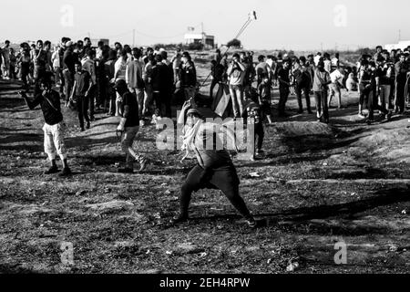 Un manifestant palestinien utilise un coup de feu pour lancer des pierres contre les forces israéliennes lors de manifestations à la frontière orientale de la ville de Gaza avec Israël. Les tensions sont vives le long de la frontière entre Gaza et Israël après plus d'un mois de manifestations de masse hebdomadaires près de la barrière qui a tué 50 manifestants palestiniens et blessé plus de 1,700 personnes par des tirs militaires israéliens. Les dirigeants du Hamas à Gaza ont promis que les marches se poursuivront jusqu'à la levée du blocus israélien de dix ans du territoire. Des manifestations sont également attendues les 14 et 15 mai, le jour où les Palestiniens marqueront Yawm an-Nakba ou 'Day of Disaste Banque D'Images