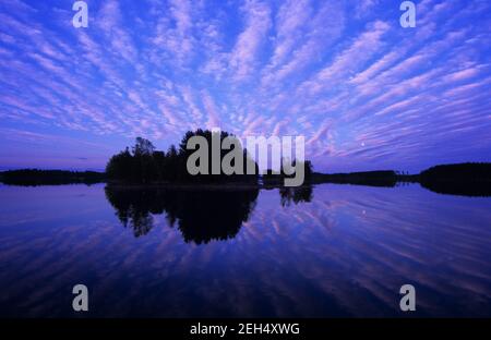 Nuages et lune se reflétant dans l'eau du lac. Banque D'Images