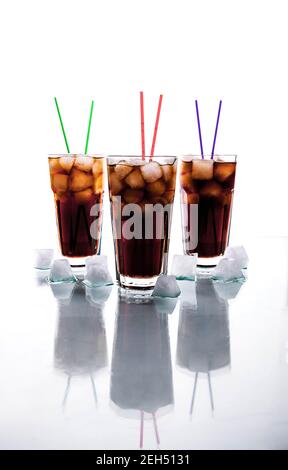 trois verres de cola avec glace et pailles sur fond blanc. boissons non alcoolisées et Banque D'Images