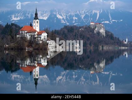 Bled, Slovénie. 19 février 2021. L'église de l'Assomption de la Vierge Marie sur l'île de Blejski Otok dans le lac Bled au pied du plateau de Pokljuka. Le château de Bled est visible en arrière-plan. Les Championnats du monde de biathlon se tiendront à Pokljuka du 10-21 au 16 février. Credit: Sven Hoppe/dpa/Alay Live News Banque D'Images