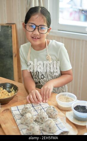 Une fille faisant une maison Onigiri Banque D'Images