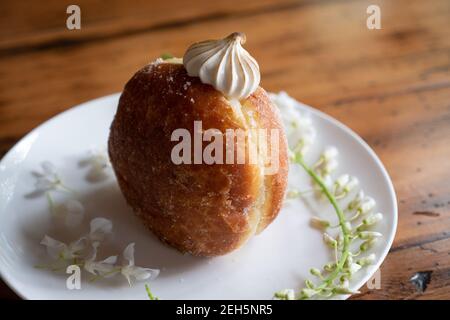 Délicieux beignet de beignet pâtisserie fait main crème de dessert sucre plat photographie esthétique fond sombre floral doux manger tentation doux Banque D'Images