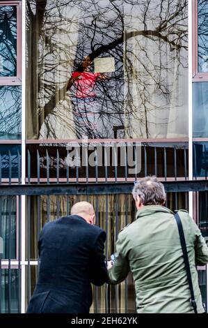 Londres, Royaume-Uni. 19 février 2021. Une femme chilienne semble assez heureuse et donne son numéro à reporter dehors et ensuite discuter avec eux en train de crier une gamme d'émotions - en quarantaine à l'hôtel Radisson Blue Edwardian - les gens sont toujours en vol via Heathrow, Mais les nouvelles restrictions de quarantaine pour les voyages internationaux depuis une liste rouge de pays signifie que certains finissent dans les hôtels près de l'aéroport pendant 10 jours. Le verrouillage national 3 est en vigueur avec l'instruction du gouvernement pour que tout le monde reste à la maison. Crédit : Guy Bell/Alay Live News Banque D'Images