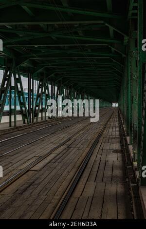 Long pont en bois et en métal avec rails de tram et vert construction Banque D'Images