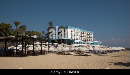 Palm Beach avec des parasols de plage et des touristes et des hôtels abandonnés à la ville fantôme, Famagousta, Chypre du Nord Banque D'Images