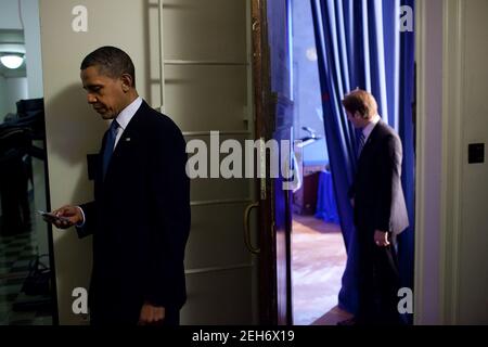 Le président Barack Obama vérifie son BlackBerry dans une salle de détention avant de faire des remarques sur le projet de loi sur la réforme de l'assurance maladie au ministère de l'intérieur, le 23 mars 2010. Banque D'Images