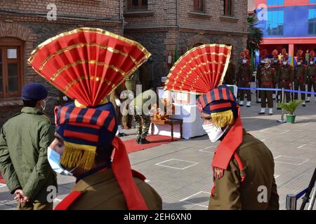 Srinagar, Inde. 19 février 2021. Un policier a déposé des fleurs sur les cercueils du défunt lors d'une cérémonie de pose de couronnes pour les deux policiers qui ont été tués lors d'une attaque militante à Srinagar. Plus tôt, trois militants et un policier ont été tués lors de deux rencontres séparées dans la vallée du Cachemire. Crédit : SOPA Images Limited/Alamy Live News Banque D'Images