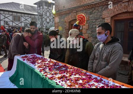 Srinagar, Inde. 19 février 2021. Des parents et des policiers se sont fait chagrin à côté du cercueil du défunt lors d'une cérémonie de dépôt de couronnes pour les deux policiers qui ont été tués lors d'une attaque militante à Srinagar. Plus tôt, trois militants et un policier ont été tués lors de deux rencontres séparées dans la vallée du Cachemire. Crédit : SOPA Images Limited/Alamy Live News Banque D'Images