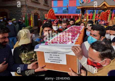 Srinagar, Inde. 19 février 2021. Les policiers et les proches portent le cercueil du défunt lors d'une cérémonie de pose de couronnes pour les deux policiers qui ont été tués lors d'une attaque militante à Srinagar. Plus tôt, trois militants et un policier ont été tués lors de deux rencontres séparées dans la vallée du Cachemire. Crédit : SOPA Images Limited/Alamy Live News Banque D'Images