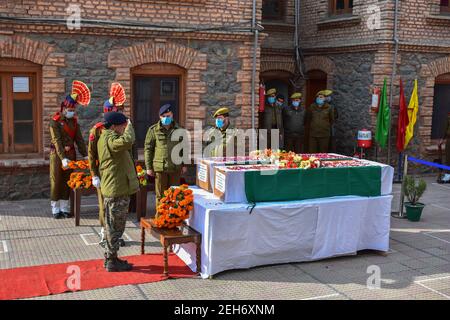 Srinagar, Inde. 19 février 2021. Un policier salue les cercueils du défunt lors d'une cérémonie de pose de couronnes pour les deux policiers qui ont été tués lors d'une attaque militante à Srinagar. Plus tôt, trois militants et un policier ont été tués lors de deux rencontres séparées dans la vallée du Cachemire. Crédit : SOPA Images Limited/Alamy Live News Banque D'Images