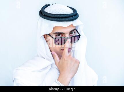 Jeune homme arabe portant des lunettes de soleil et des lunettes de peeking Banque D'Images