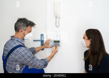 Installation du système d'alarme de sécurité par le technicien dans le masque facial Banque D'Images