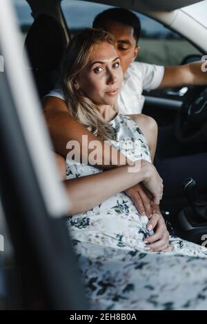 Un couple heureux en voiture. Embrasser homme et femme dans une voiture Banque D'Images