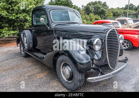 Une belle restauration sur un modèle tardif années 1930 noir Ford camion avec des gouttelettes de pluie sur le capot et d'autres vintage voitures en arrière-plan à un salon de voiture je Banque D'Images