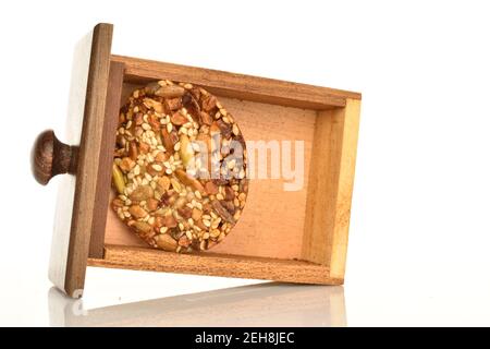 Un délicieux biscuit doux aux noix frais et parfumé se trouve dans une boîte en bois, marron, sur fond blanc. Banque D'Images