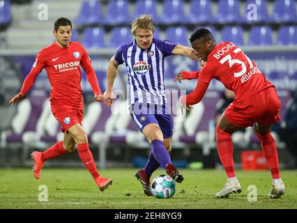 Aue, Allemagne. 19 février 2021. Football : 2. Bundesliga, FC Erzgebirge Aue - VfL Bochum, Matchday 22, à Erzgebirgsstadion. Jan Hochscheidt (M) d'Aue contre l'Armel Bella Kotchap (r) de Bochum et Cristian Gamboa. Credit: Robert Michael/dpa-Zentralbild/dpa - NOTE IMPORTANTE: Conformément aux règlements de la DFL Deutsche Fußball Liga et/ou de la DFB Deutscher Fußball-Bund, il est interdit d'utiliser ou d'avoir utilisé des photos prises dans le stade et/ou du match sous forme de séquences et/ou de séries de photos de type vidéo./dpa/Alay Live News Banque D'Images