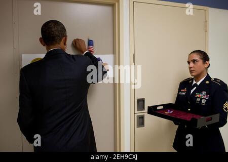 Le président Barack Obama frappe sur la porte avant d'entrer dans la chambre d'un soldat au centre médical de l'armée Walter Reed à Washington, D.C., le 30 août 2010. Le Président a rencontré 24 guerriers blessés qui ont servi en Afghanistan, cinq en Irak, et a honoré 11 soldats au cœur violet. Banque D'Images