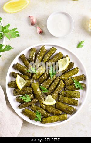 Dolma, feuilles de raisin farcies sur fond de pierre légère. Vue de dessus, plan d'appartement Banque D'Images