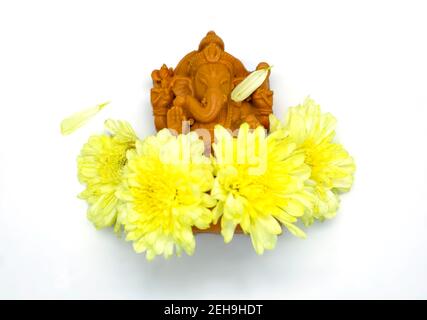 Statue de Ganesha avec fleurs jaunes de Dieu hindou sur blanc arrière-plan dans les vues de dessus Banque D'Images