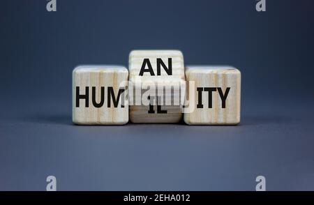 Humilité contre symbole de l'humanité. A tourné des cubes et a changé le mot 'humilité' en 'humanité'. Belle table grise, fond gris, espace de copie. Affaires a Banque D'Images