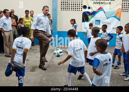 Le président Barack Obama joue du football avec des enfants au Centre communautaire de Cidade de Deus (ville de Dieu) favela à Rio de Janeiro, Brésil, le 20 mars 2011. Banque D'Images