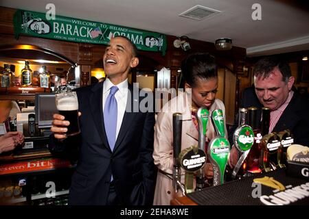 Le président Barack Obama s'entretient avec les amateurs de pub alors que la première dame Michelle Obama dessine une pinte au pub Ollie Hayes à Moneygall, en Irlande, le 23 mai 2011. Banque D'Images