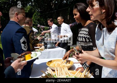 Le président Barack Obama, le Premier ministre britannique David Cameron, la première dame Michelle Obama et Samantha Cameron servent des familles militaires lors d'un barbecue dans le jardin du 10 Downing Street à Londres, en Angleterre, le 25 mai 2011. Banque D'Images