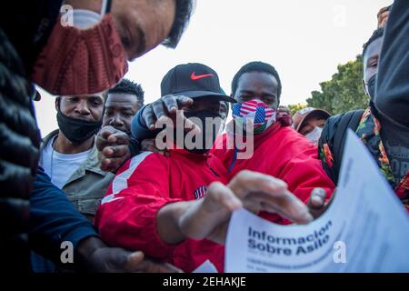 Tijuana, Mexique. 19 février 2021. Les migrants peuvent obtenir des fiches d'information sur la façon de demander l'asile aux États-Unis au poste-frontière « El Chaparral ». Suite à l'annonce du changement d'orientation de la politique migratoire des États-Unis, un grand nombre de migrants se sont rassemblés à la frontière entre le Mexique et les États-Unis dans le contexte de la pandémie de Corona. Credit: Jair Cabrera Torres/dpa/Alay Live News Banque D'Images