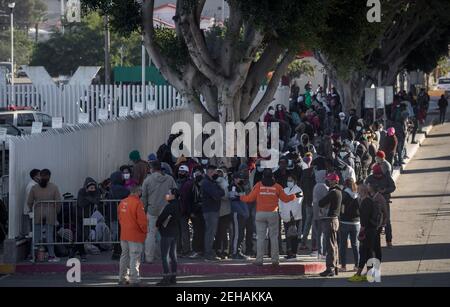 Tijuana, Mexique. 19 février 2021. Les migrants attendent au passage frontalier d'El Chaparral, au milieu de la pandémie de Corona. Suite à l'annonce du changement d'orientation de la politique migratoire des États-Unis, un grand nombre de migrants se sont rassemblés à la frontière entre le Mexique et les États-Unis dans le contexte de la pandémie de Corona. Crédit : Stringer/dpa/Alay Live News Banque D'Images