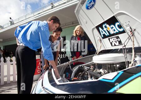 La première dame Michelle Obama et le Dr Jill Biden regardent Carl Edwards, pilote de NASCAR, pour leur rappeler les caractéristiques sous le capot de sa voiture de secours avant le début de la course Ford 400 au Homestead-Miami Speedway à Homestead, en Floride, le 20 novembre 2011. Banque D'Images