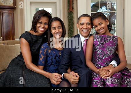 Le président Barack Obama, la première dame Michelle Obama et leurs filles, Sasha et Malia, sont assis pour un portrait de famille dans le Bureau ovale, le 11 décembre 2011. Banque D'Images