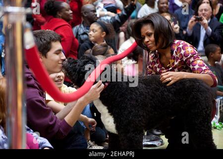 La première dame Michelle Obama et Bo, le chien de la famille Obama, accueillent les membres de l’audience au Centre médical national pour enfants à Washington, D.C., le 12 décembre 2011. Mme Obama a lu "Twas the night before Christmas" lors d'un programme de vacances de Noël avec des enfants, des parents et du personnel. Banque D'Images