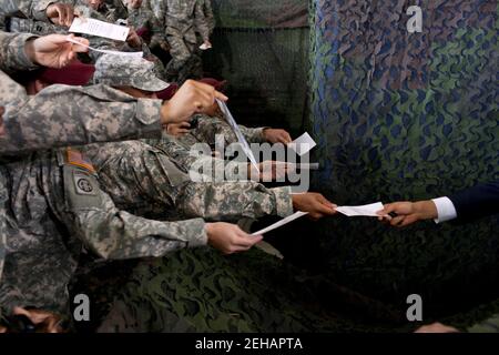 Le président Barack Obama est remis un morceau de papier à un autographe à la suite de remarques sur la fin de la guerre des États-Unis en Irak, à l’aérodrome du Pape Army, fort Bragg, N.C., le 14 décembre 2011. Banque D'Images