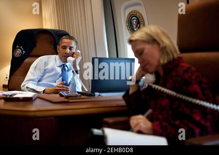 Le président Barack Obama s'entretient au téléphone avec le président élu Vladimir Poutine de Russie à bord de l'Air Force One en route vers Richmond, en Virginie, le 9 mars 2012. Alice Wells, directrice principale des affaires russes, écoute l'appel. Banque D'Images