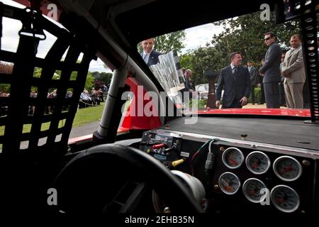 Le président Barack Obama regarde le trophée NASCAR Sprint Cup Series Championship lorsqu'il approche de la voiture de Tony Stewart lors d'un événement sur la pelouse sud de la Maison Blanche, le 17 avril 2012. Pilotes NASCAR Sprint Cup Series Tony Stewart, centre, Kyle Busch, et Ryan Newman, à droite, regardez à proximité. Banque D'Images